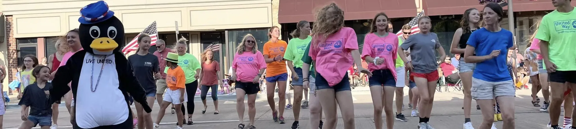 Community members dance together before the 4th of July parade